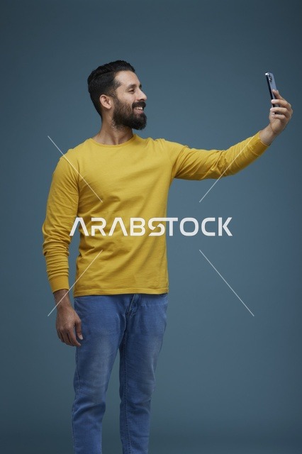 شاب سعودي يلتقط سيلفي بالهاتف الذكي في استوديو