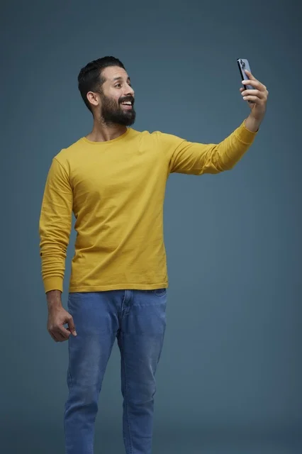 Saudi Man Taking Selfie with Smartphone in Yellow Shirt