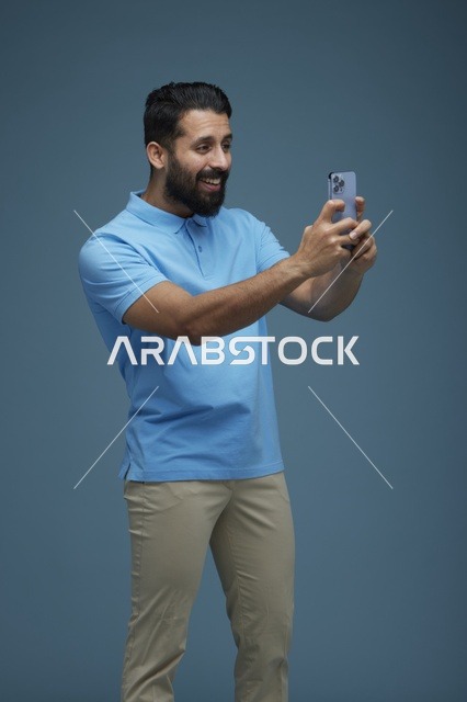 شاب سعودي يلتقط سيلفي بالهاتف الذكي بملابس كاجوال