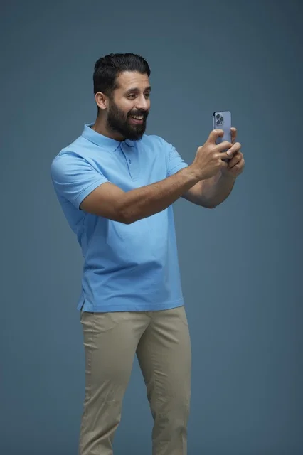Saudi Man Taking Selfie with Smartphone in Casual Clothes