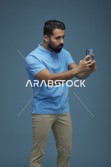 شاب سعودي يلتقط سيلفي بالهاتف الذكي بملابس كاجوال