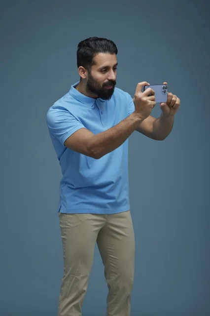 شاب سعودي يصور بالهاتف الذكي بخلفية زرقاء