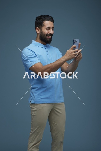 شاب سعودي يلتقط سيلفي بالهاتف الذكي بملابس كاجوال