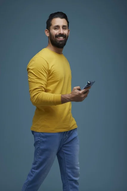 Saudi Man with Smartphone on Blue Studio Background