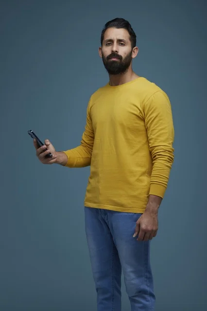 Saudi Man with Smartphone on Blue Background