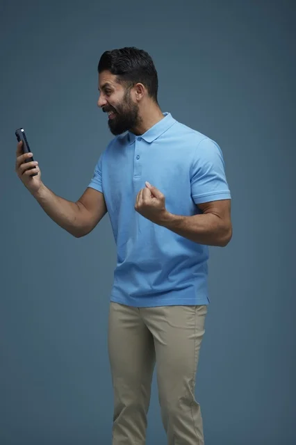 Excited Saudi Man with Smartphone Celebrating Success