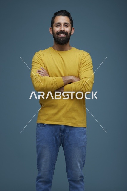 شاب سعودي مبتسم بملابس كاجوال في استوديو
