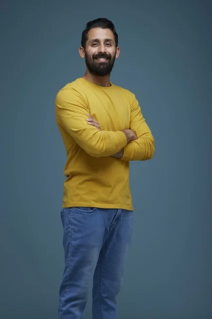 Smiling Saudi Man in Yellow Casual Shirt on Blue Background