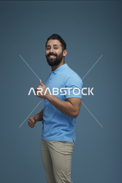 شاب سعودي بملابس كاجوال يقوم بإيماءة الإبهام للأعلى