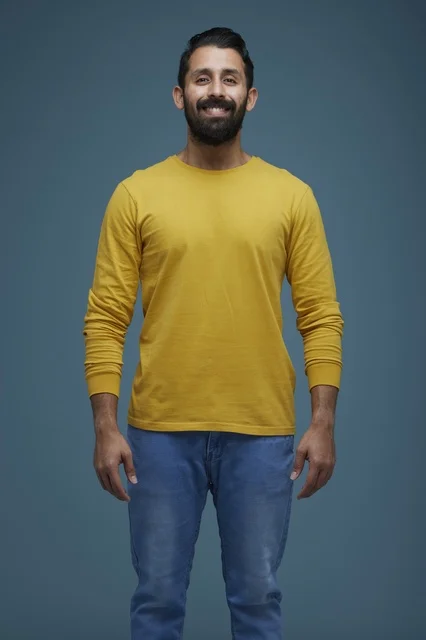 Smiling Saudi Man in Yellow Shirt Blue Background