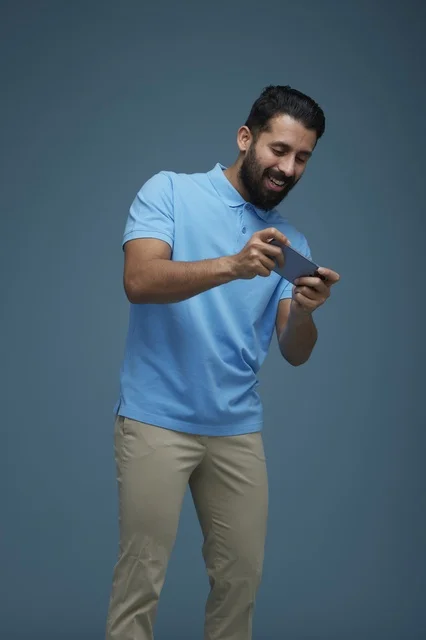 Saudi Man Playing Mobile Game on Smartphone in Studio