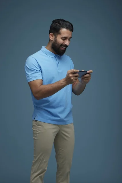 Saudi Man Playing Mobile Game on Smartphone in Studio