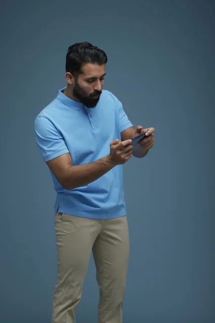 Saudi Man Playing Mobile Game on Smartphone in Studio