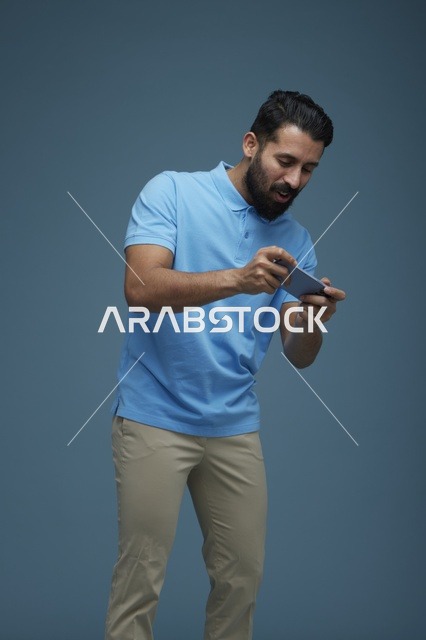 شاب سعودي يلعب ألعاب الجوال على الهاتف الذكي