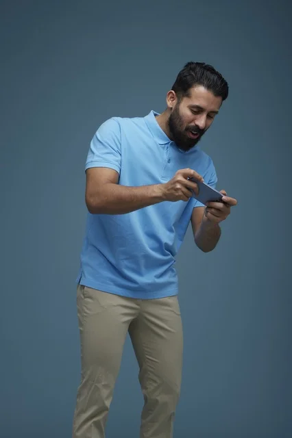 Saudi Man Playing Mobile Game on Smartphone