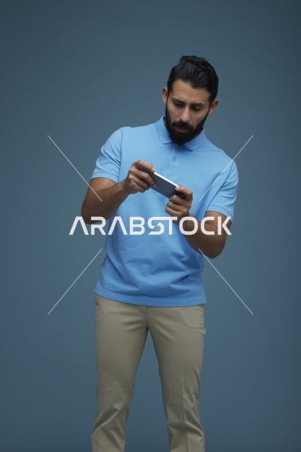 شاب سعودي يلعب لعبة على الهاتف في الاستوديو