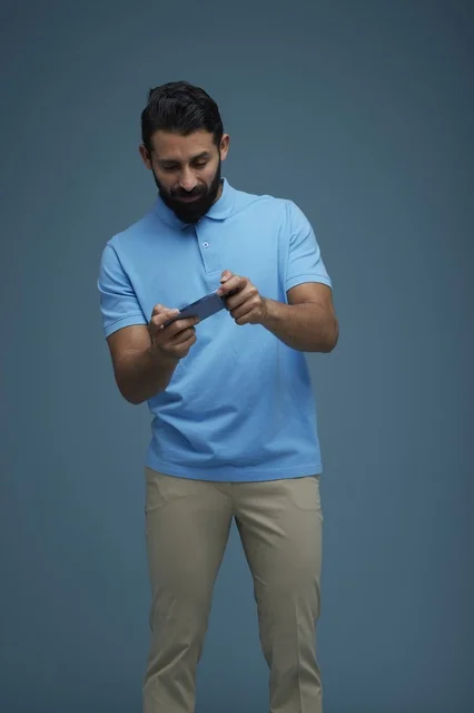 Saudi Man Playing Mobile Game in Casual Clothes Studio