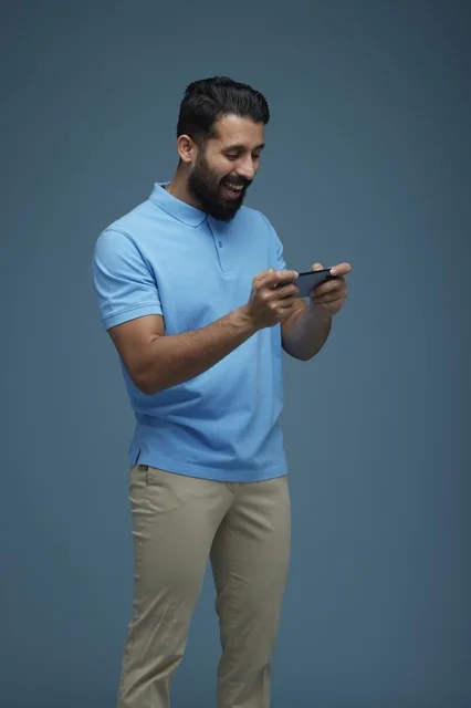 Saudi Man Playing Mobile Game on Smartphone in Studio