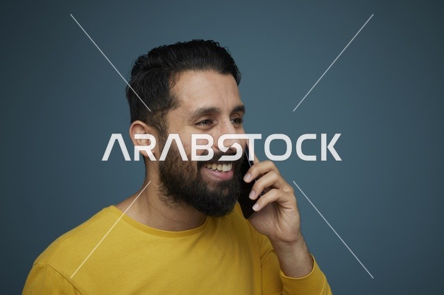 شاب سعودي يتحدث بالهاتف الذكي بملابس كاجوال