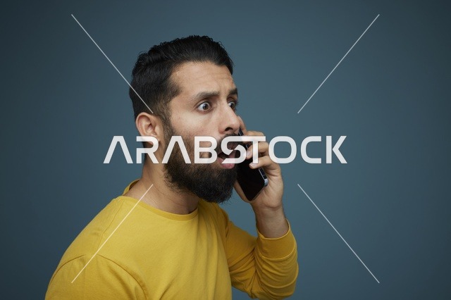 شاب سعودي مصدوم يتحدث عبر الهاتف بملابس كاجوال