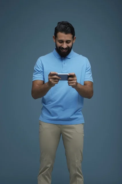 Saudi Man Playing Mobile Game on Smartphone in Studio