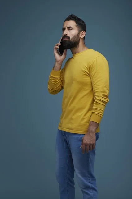 Saudi Man Talking on Smartphone in Casual Yellow Shirt