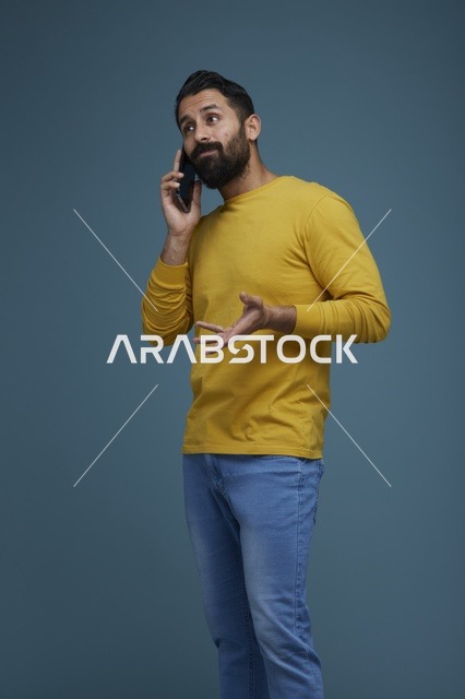 شاب سعودي يتحدث بالهاتف بملابس كاجوال صفراء