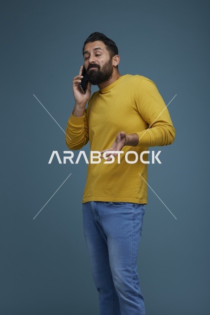 شاب سعودي يتحدث عبر الهاتف الجوال بملابس كاجوال