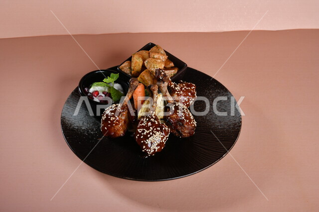 A plate of crispy fried chicken pieces with sauce and honey, fried potato cubes and delicious salad, Arabic meals, delicious recipes and food dishes, delicious meals, Gulf Arab restaurants