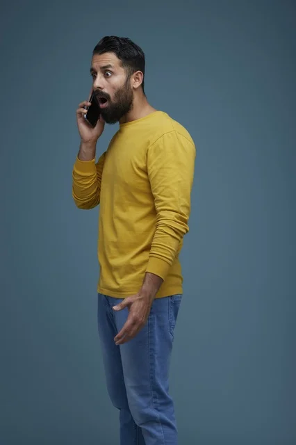 Surprised Saudi Man Talking on Smartphone in Studio