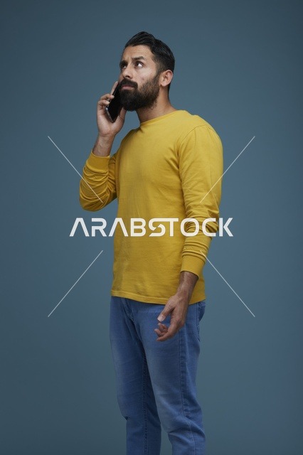 شاب سعودي يتحدث عبر الهاتف بملابس كاجوال