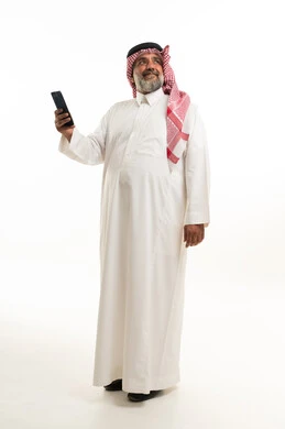 رجل سعودي مسن يحمل هاتف ذكي بخلفية بيضاء