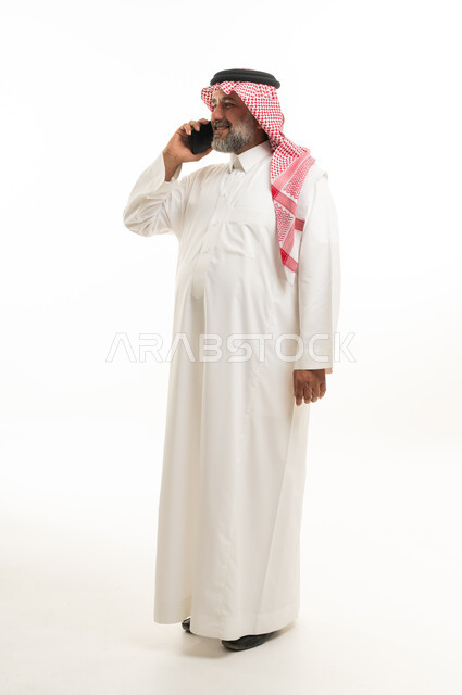 رجل سعودي يتحدث بالهاتف على خلفية بيضاء