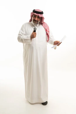 رجل سعودي يقدم خطاباً بميكروفون خلفية بيضاء