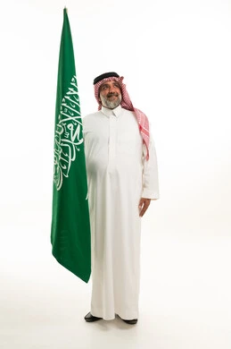Saudi Man with National Flag in Traditional Attire