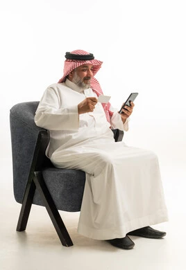 رجل سعودي يستخدم بطاقة الائتمان والهاتف الذكي
