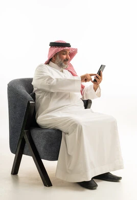 Saudi Man in Traditional Thobe Using Smartphone