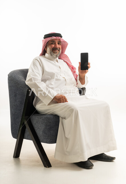 Saudi Man in Traditional Thobe Holding Smartphone