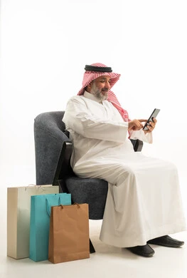 Saudi Man Using Smartphone with Shopping Bags on White