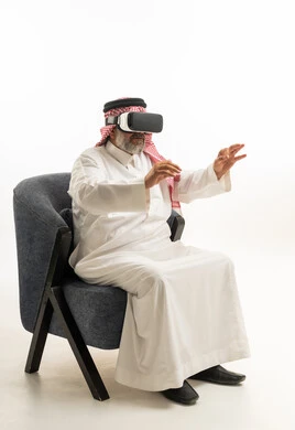رجل سعودي يستخدم نظارة الواقع الافتراضي بالزي التقليدي