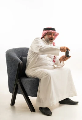 Saudi Senior Man Playing Video Games in Traditional Dress
