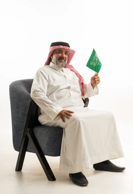 Saudi Man in Traditional Thobe Holding National Flag