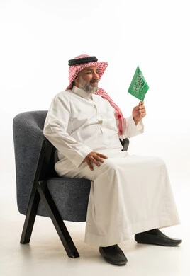 Saudi Man in Traditional Dress Holding Saudi Flag