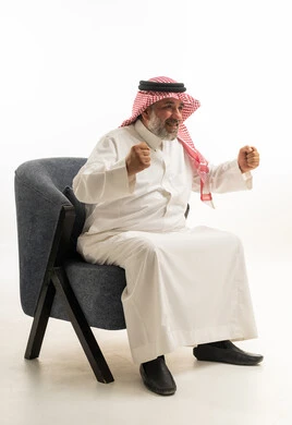 Senior Saudi Man Celebrating Success on Armchair