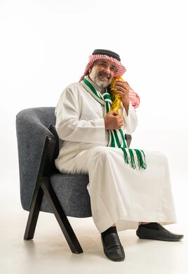 رجل سعودي بالزي التقليدي يحمل كأساً ذهبياً