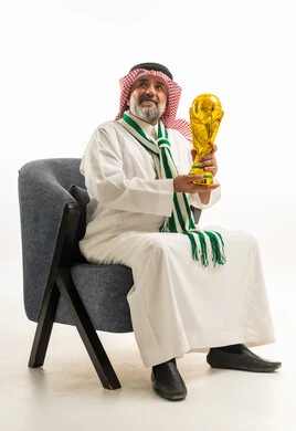 Saudi Man Holding Gold Trophy Sitting on Studio Chair
