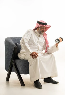 Saudi Man Exercising with Dumbbell on Blue Chair