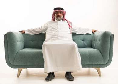 Senior Saudi Man in Traditional Dress on Sofa