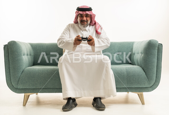 رجل سعودي يلعب ألعاب الفيديو على الأريكة