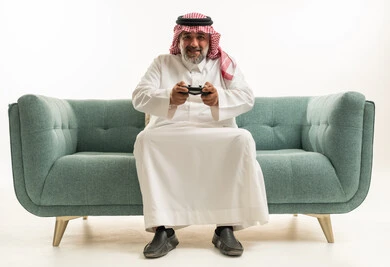 رجل سعودي يلعب ألعاب الفيديو على الأريكة
